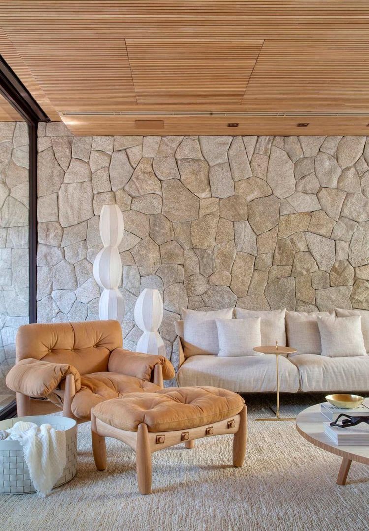 Sala de estar com parede revestida em pedra natural New Gold